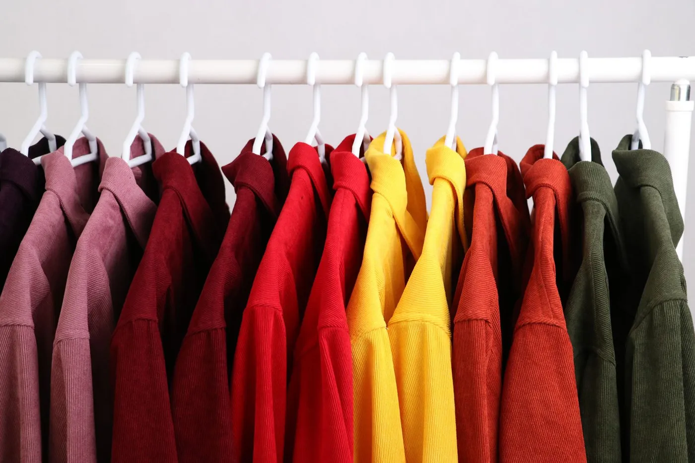 Colourful shirts arranged side by side on a clothing rail