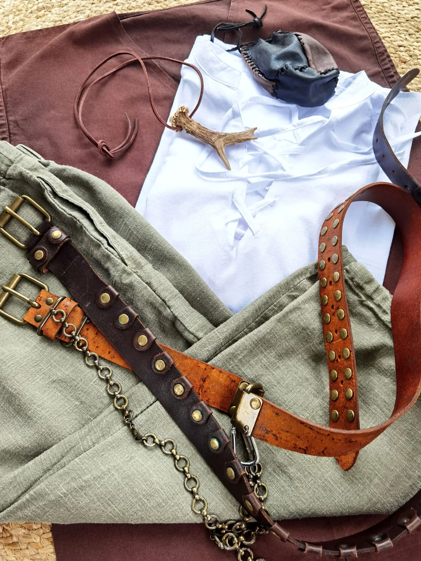 Leather belts and clothing arranged in a fashion flat lay