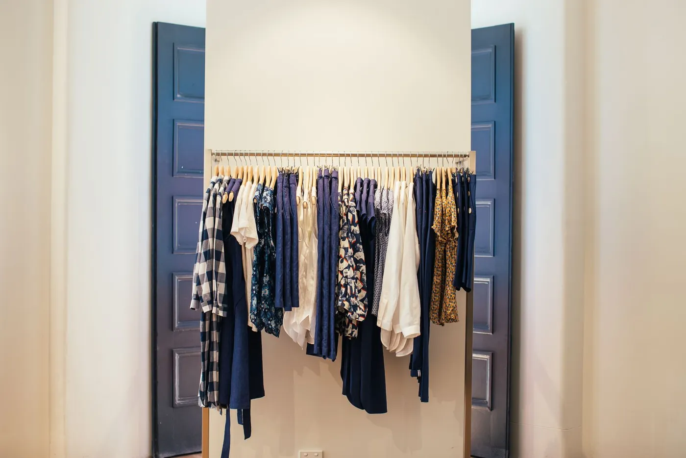 Neutral shirts and jackets neatly arranged on a clothes rail