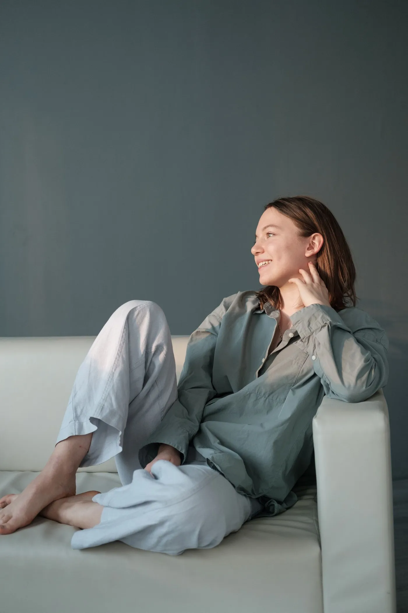 Woman relaxing on a sofa in a comfortable linen outfit