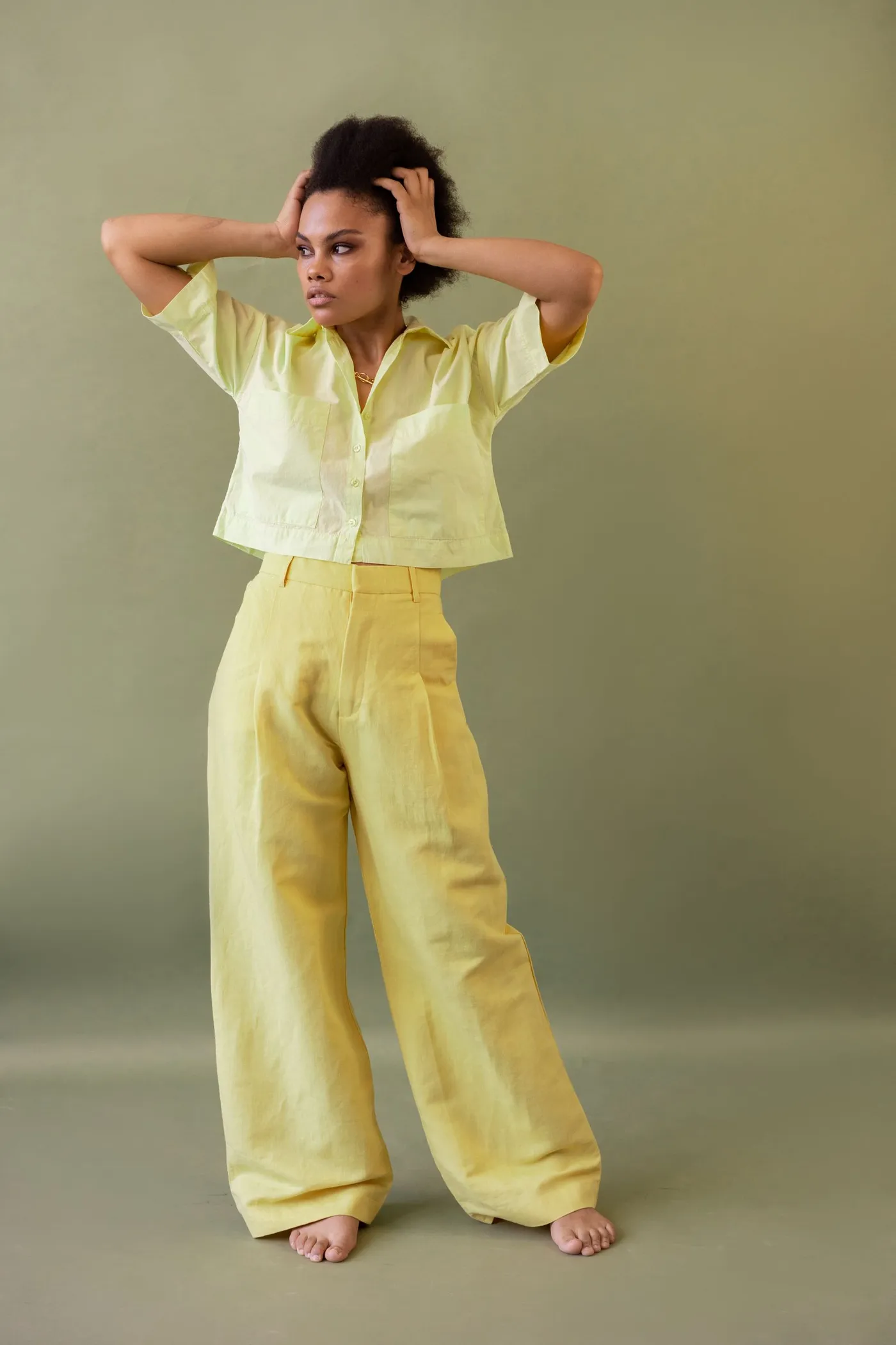 Woman wearing a coordinated yellow outfit against a green background