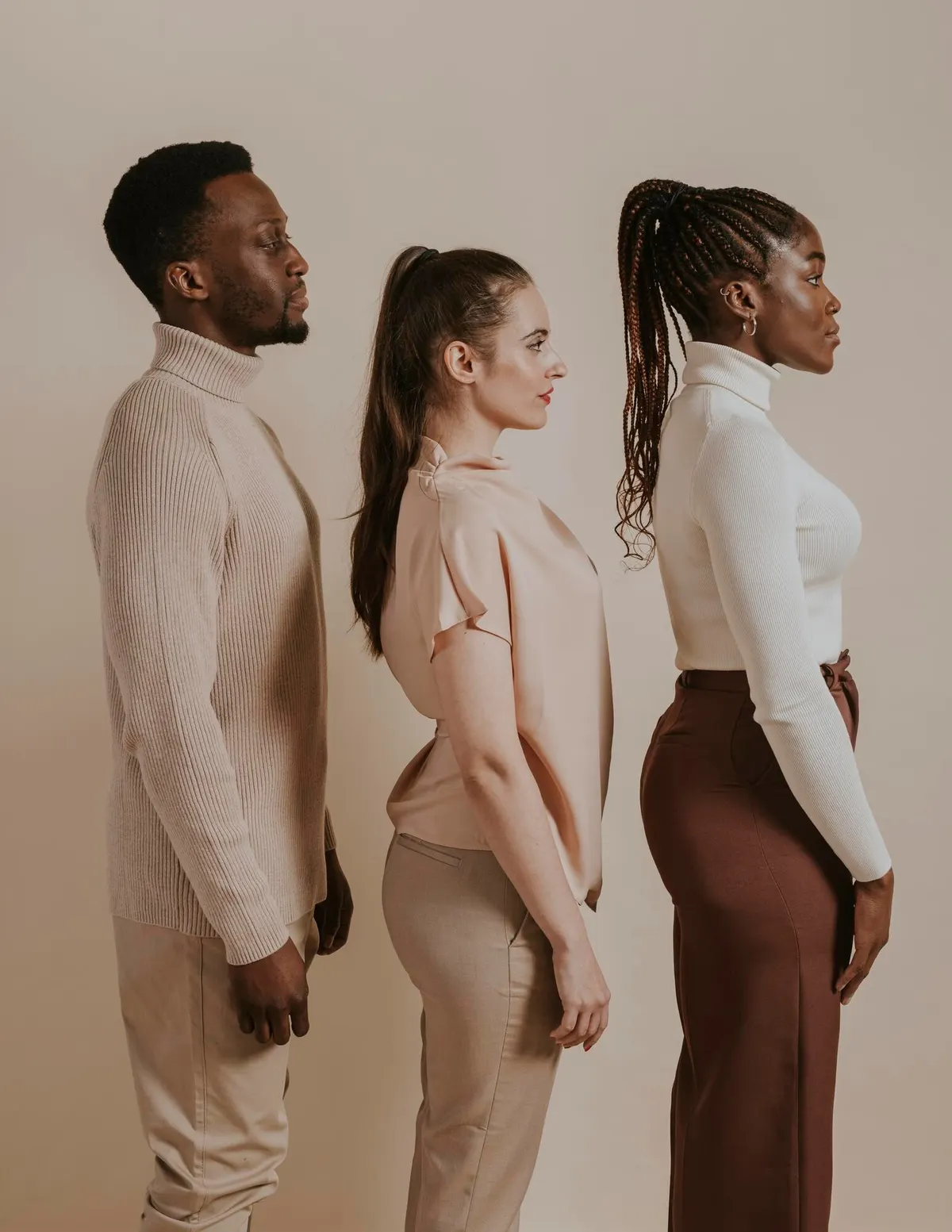 Three women wearing coordinated neutral outfits