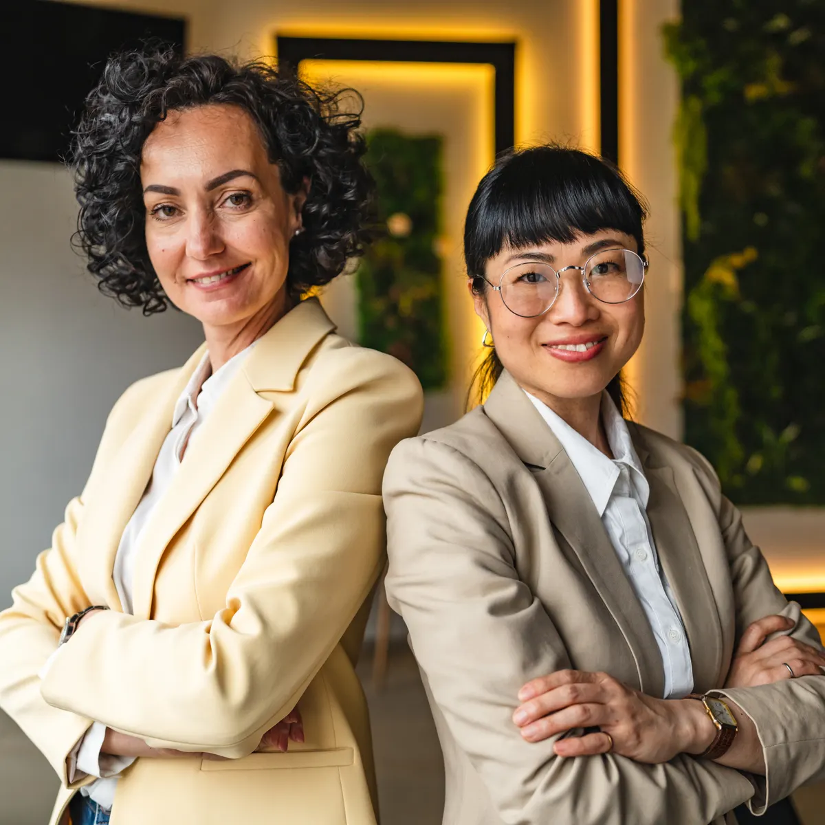 Two women wearing softly tailored blazers