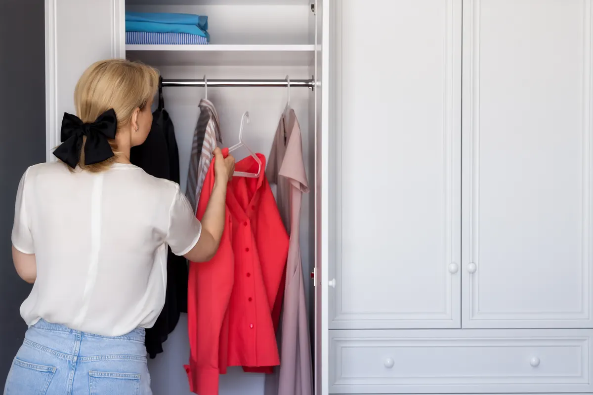 Woman choosing a bright red garment from her wardrobe