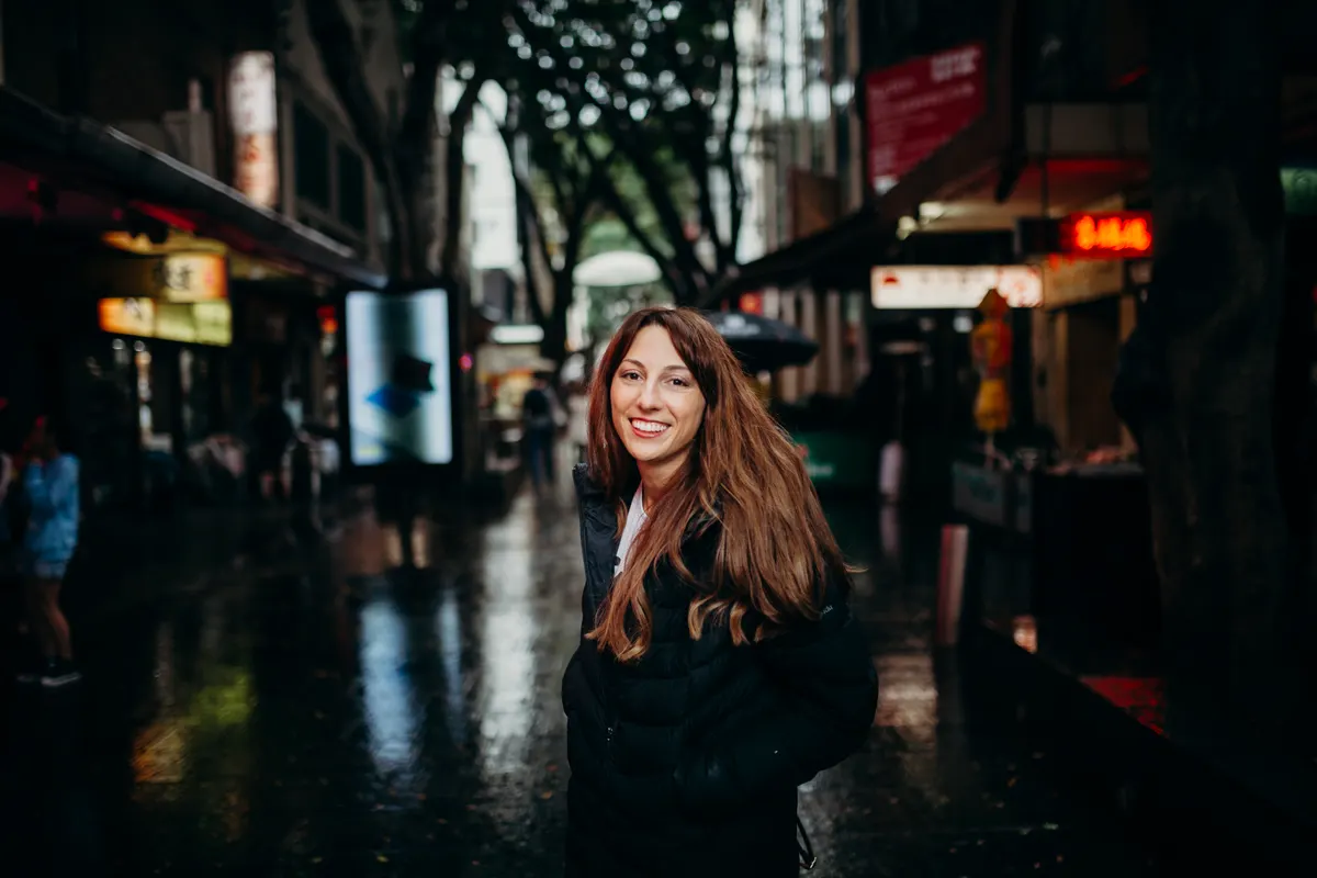 Woman wearing a dark jacket on a city street