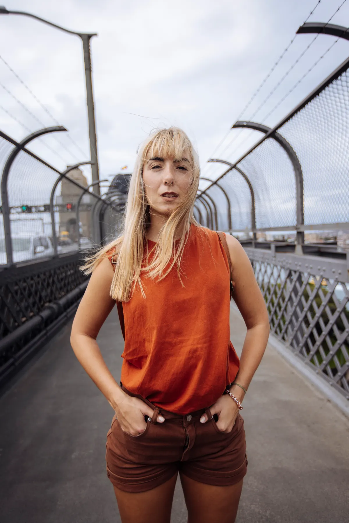 Woman wearing a vibrant orange top with dark trousers