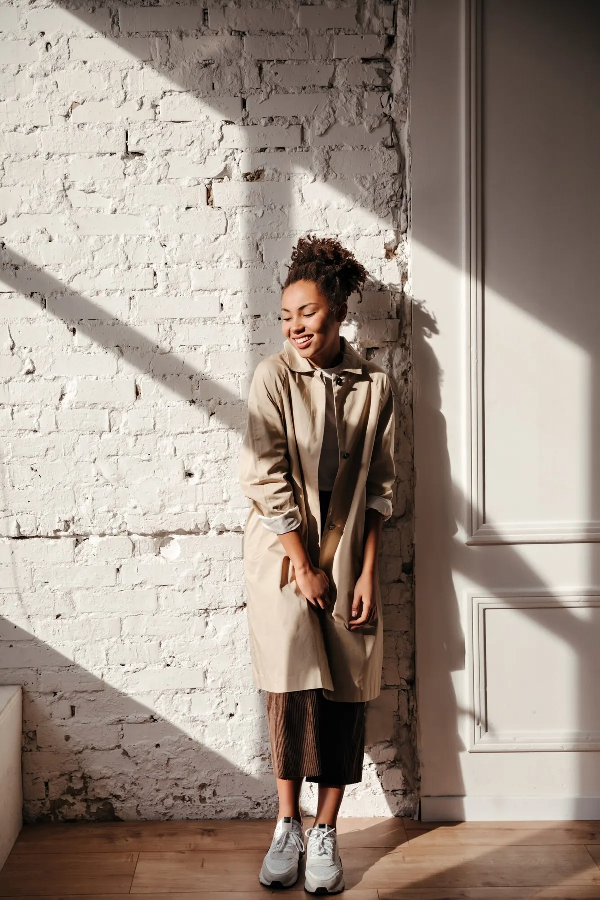 Woman wearing a long coat with cropped dark trousers