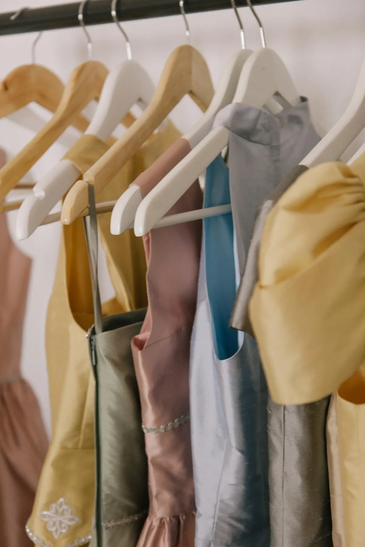 A considered selection of light clothing on wooden hangers