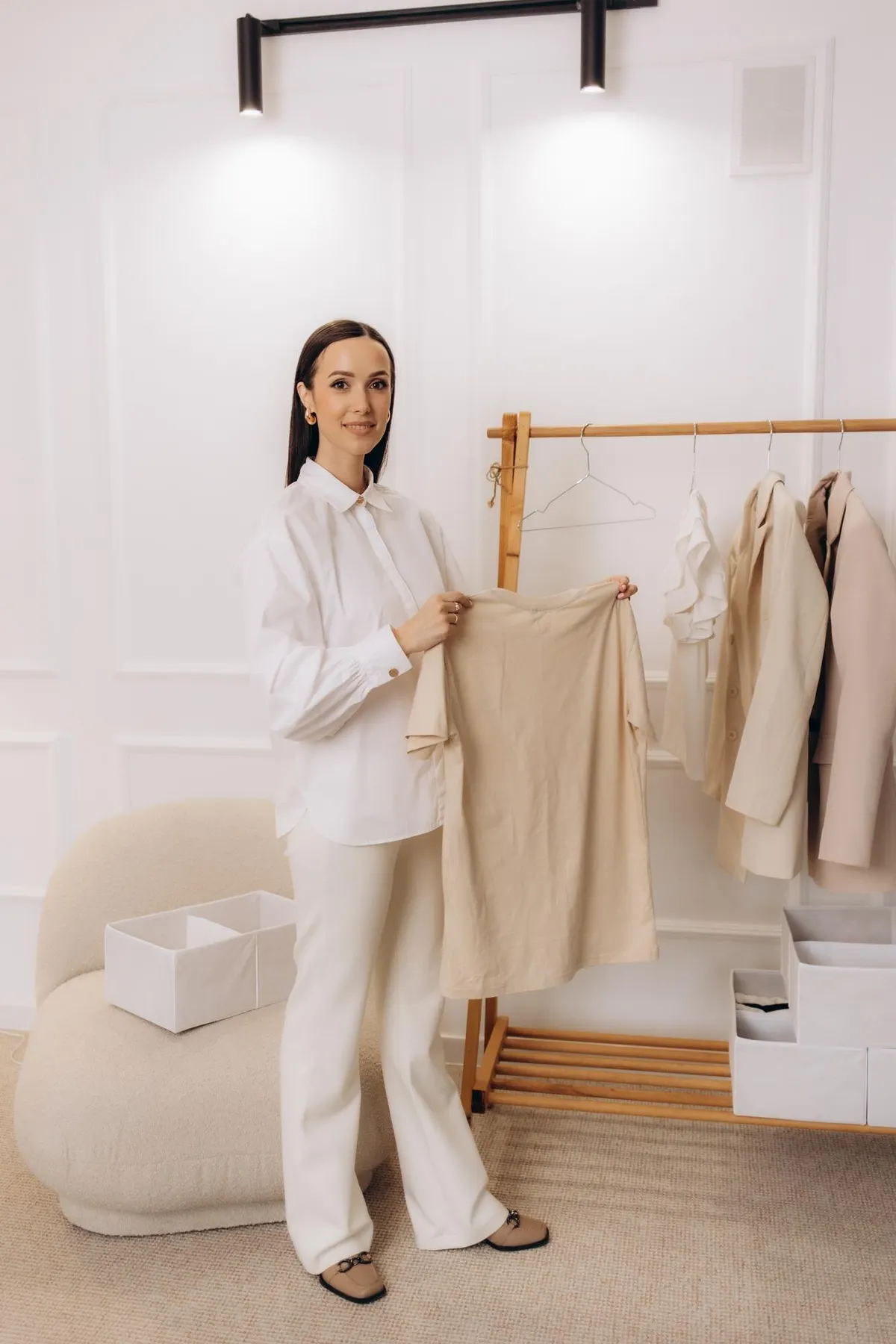 Woman selecting garments from a minimal clothing rail
