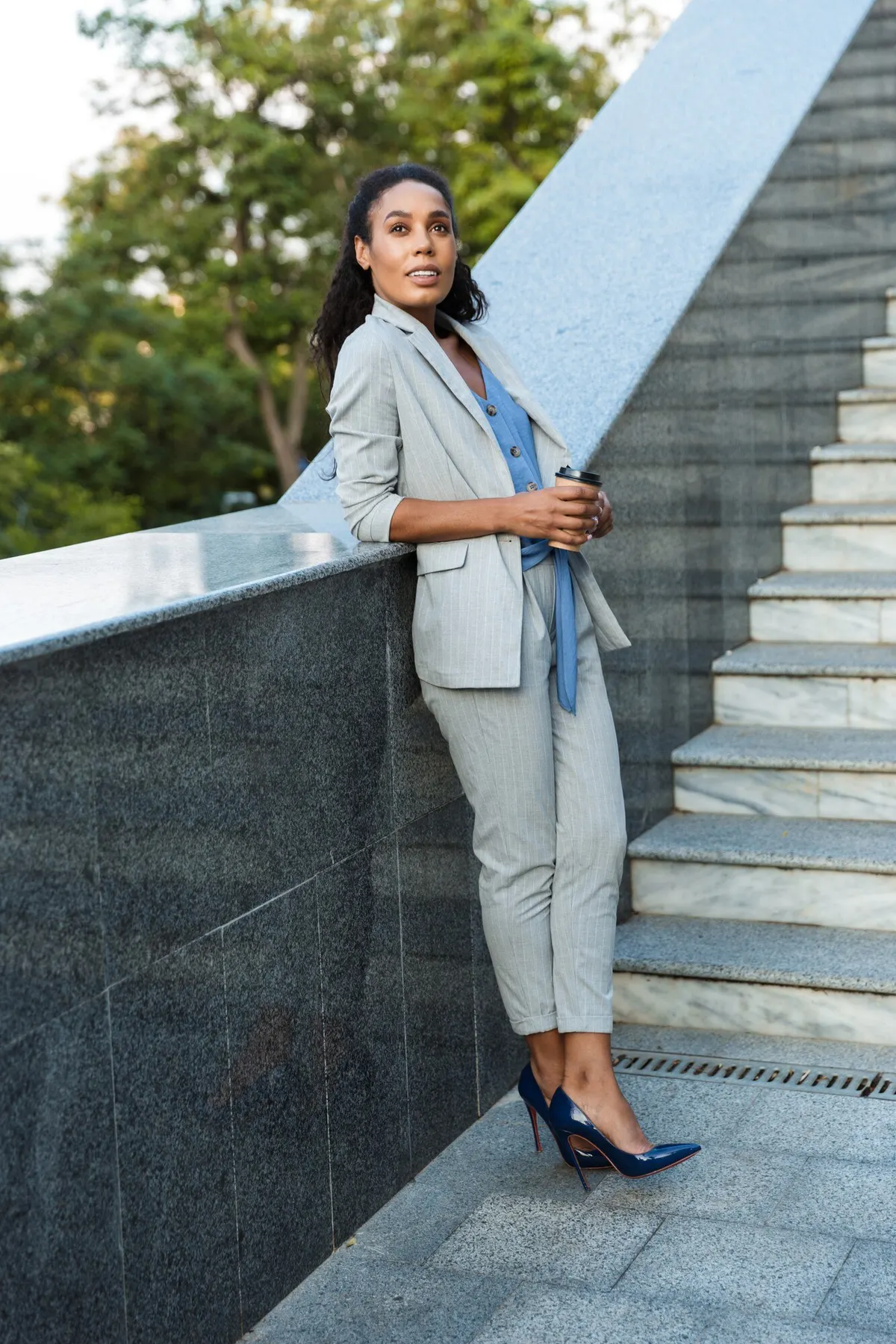 Woman pairing a pale blue jacket with jeans outdoors