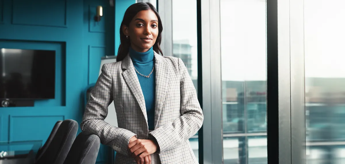 Woman wearing a grey blazer in a contemporary office