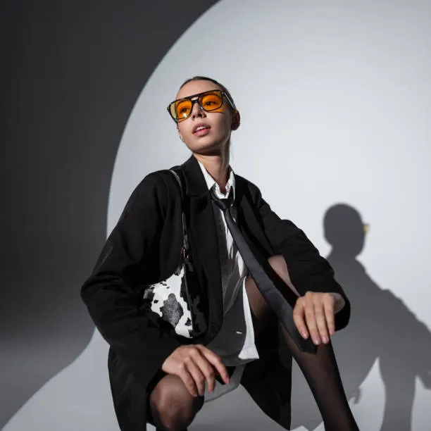 Woman styling a dark blazer with a patterned neck scarf
