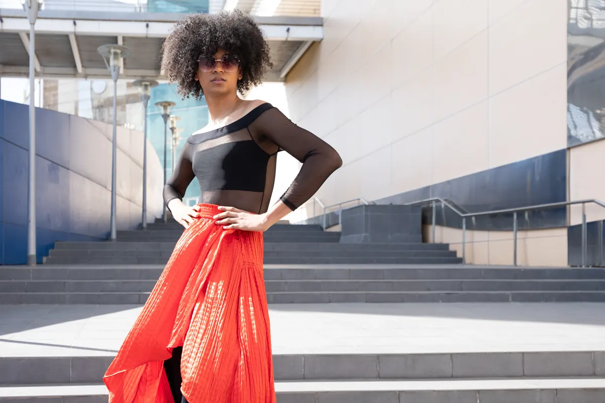 Woman pairing a black top with a vibrant red skirt