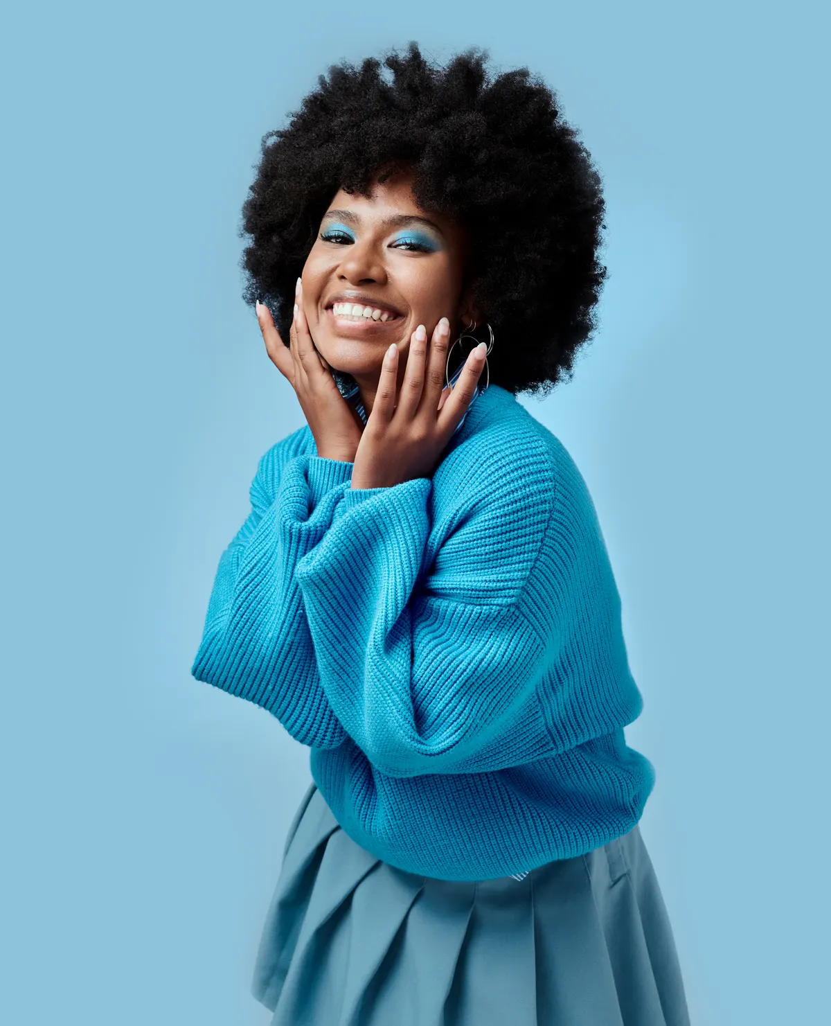 Woman wearing a bright blue blouse against a blue backdrop