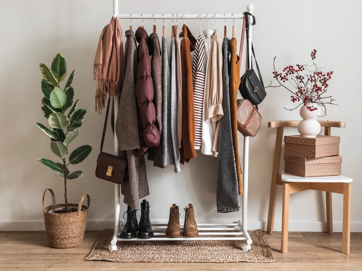 Clothes and shoes organised on a freestanding wardrobe rail