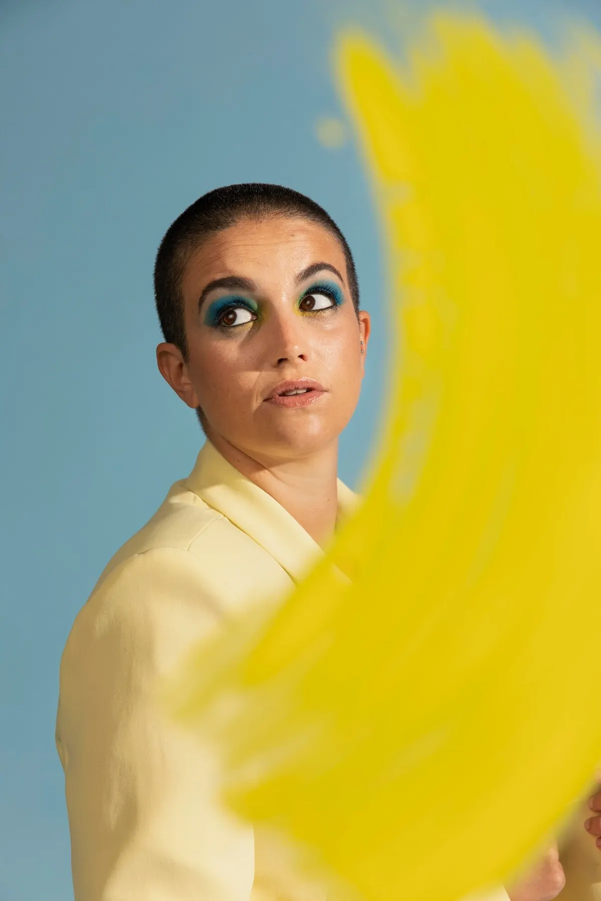 Woman wearing a bright yellow top against a blue background