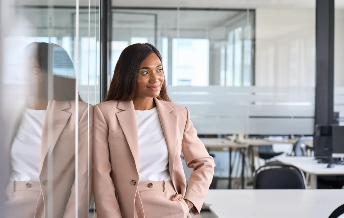 Woman wearing a soft pink blazer in an office