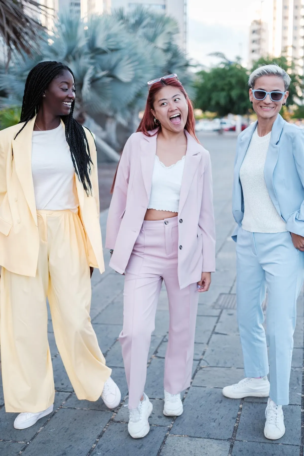 Women walking together in light pastel outfits