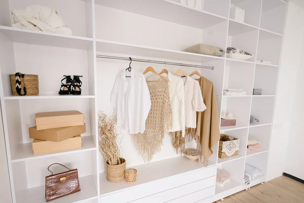 A light neutral wardrobe organised with bags and shoes
