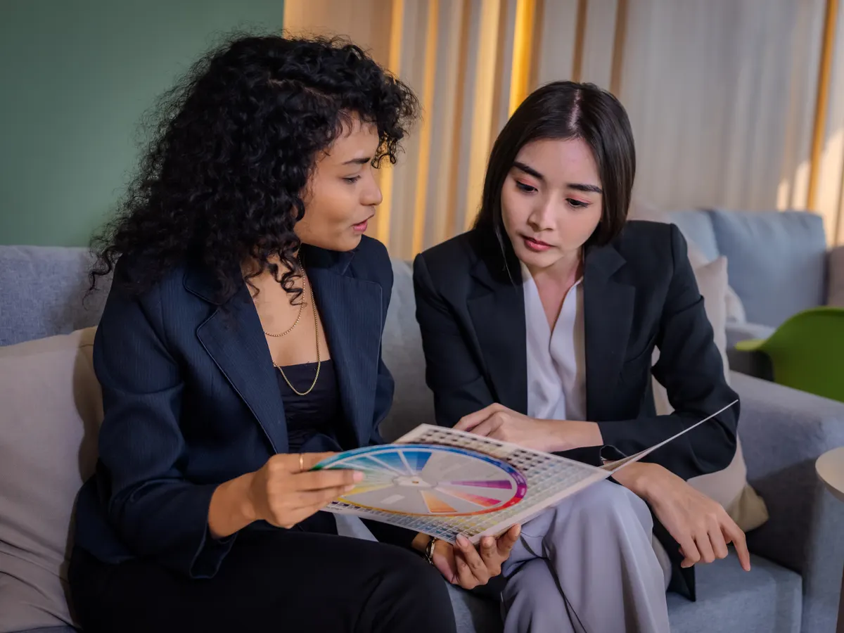 Two women reviewing documents in tailored jackets