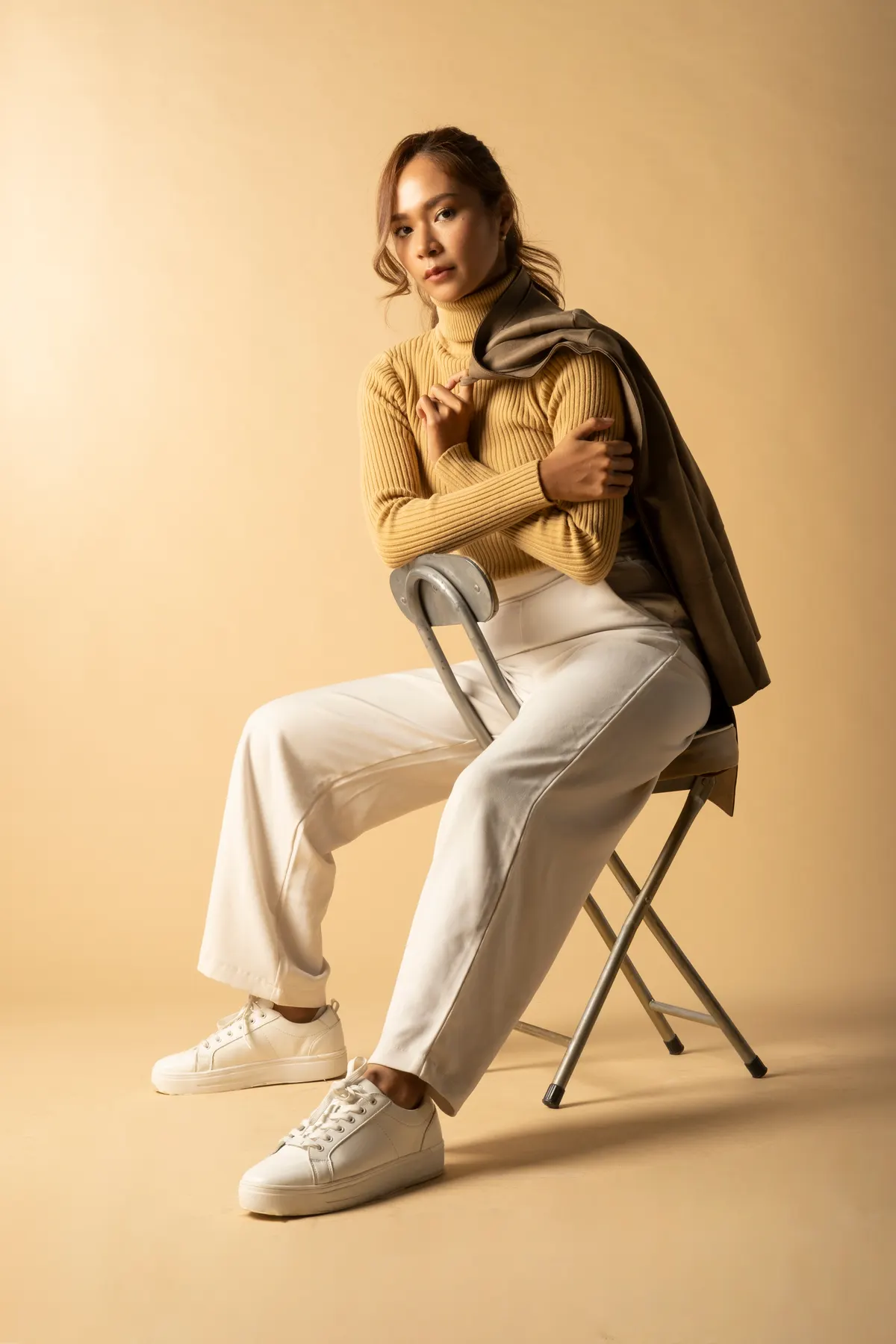 Woman wearing a golden outfit with a softly structured silhouette
