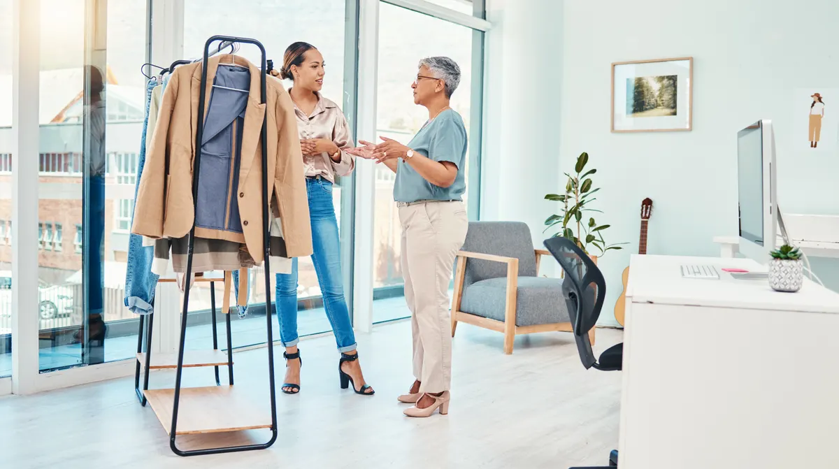 Woman arranging clothes on a rail in a bright room