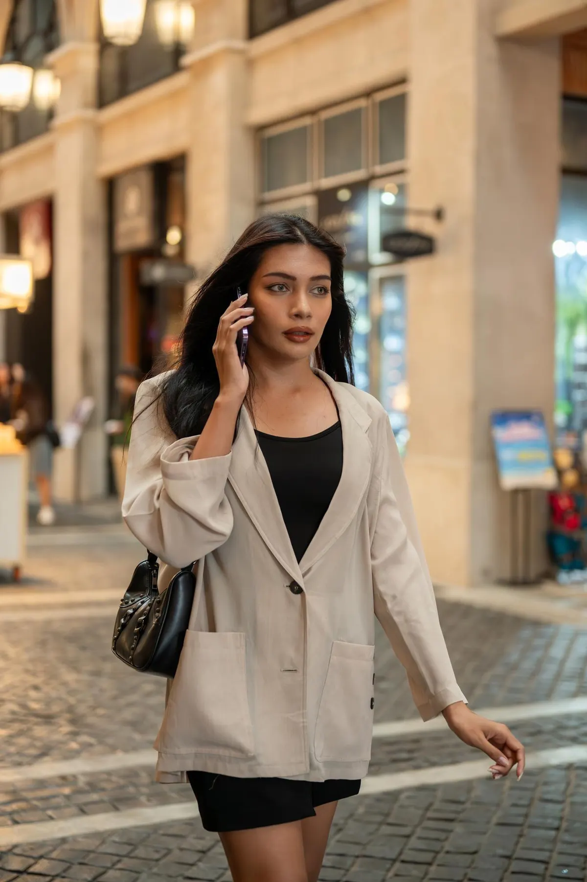Woman wearing a pale blazer and trousers on a city street