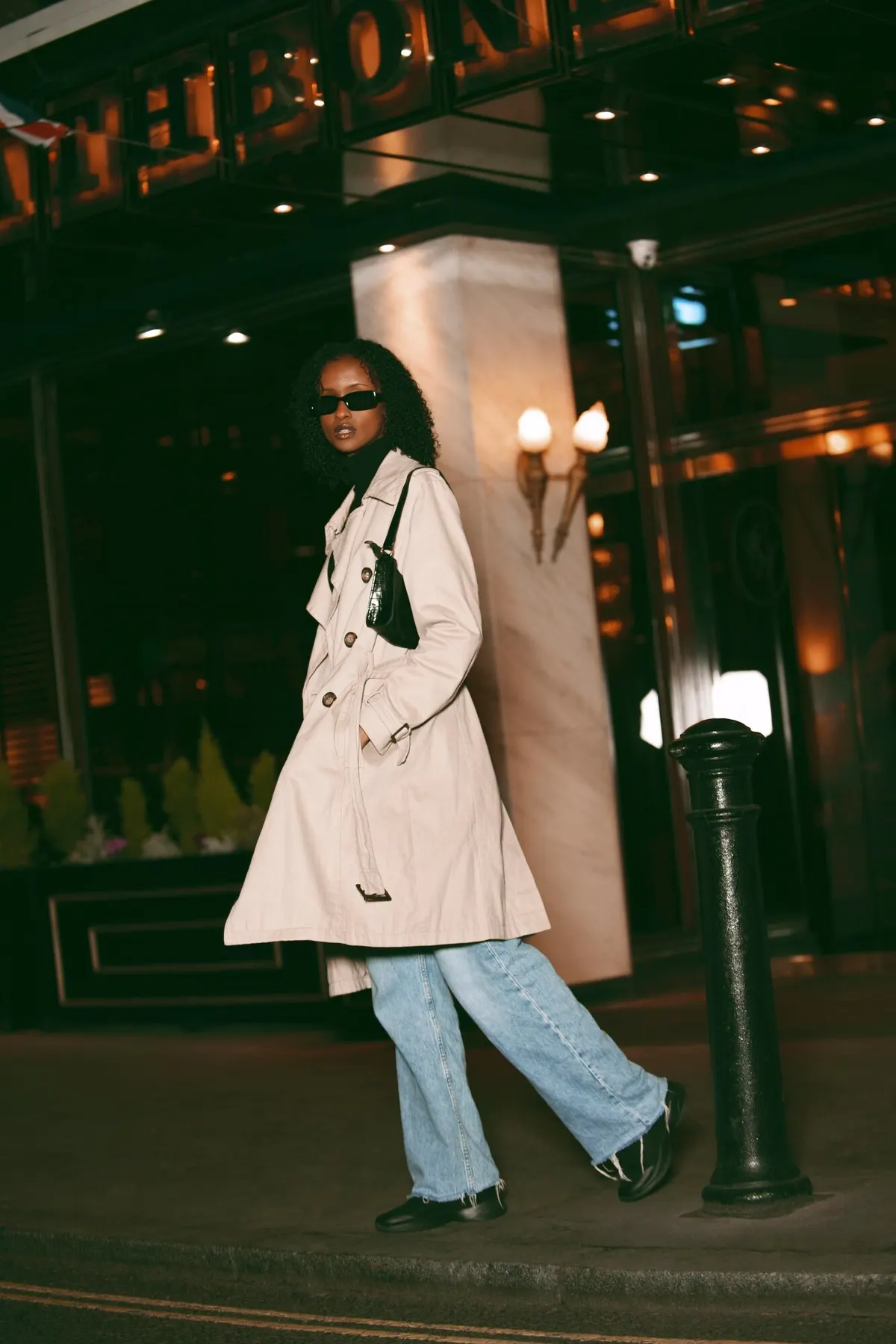 Woman wearing a pale coat outside a boutique