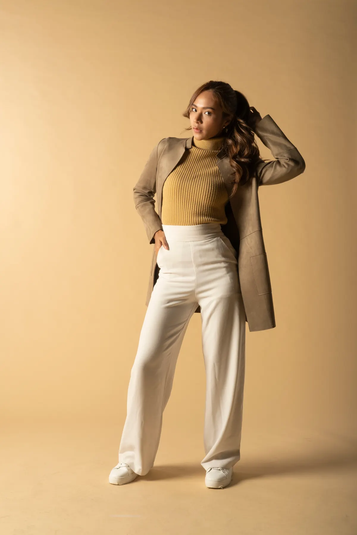 Woman combining a metallic top with pale trousers