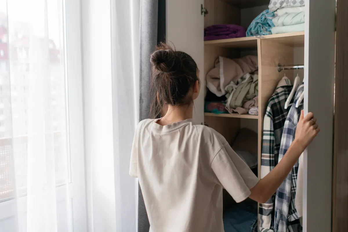 Woman considering dark garments in her wardrobe