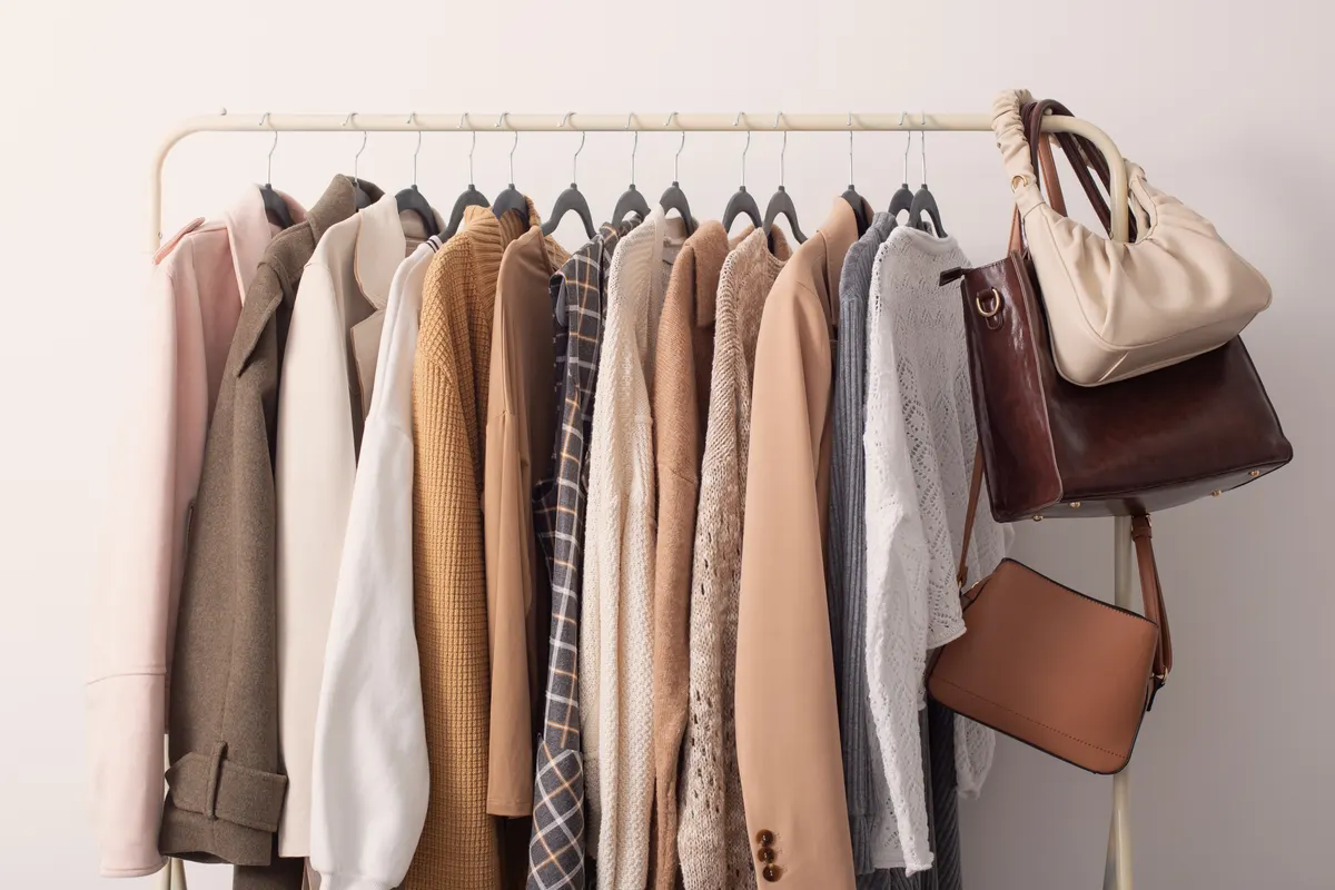 Neutral clothing and bags arranged together on a rail