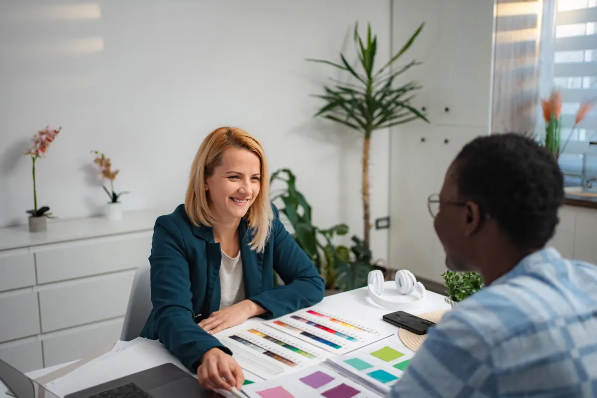 Two women discussing fabric colour samples in a styling consultation